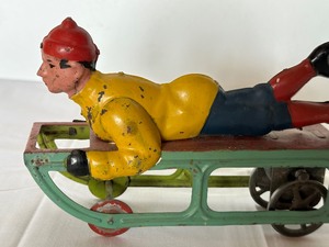 lot 10 image: Antique Pressed Steel Figurine on Sled