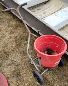 lot 70 image: HM Iron Tree Spade 43-inches tall and a 2-inch Diameter Steel Post Driver and a Sears Plastic Fertilizer Spreader (One Wheel is not turning)