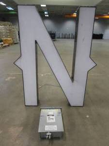 lot 101 image: Lighted Letter N Outdoor Signage With Transformer. Approximate Dimensions 35 x 5.25 x 42.5 Tall - USED FOR RETAIL BRAND MN HOME OUTLET.