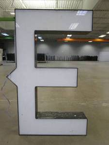 lot 122 image: Lighted Letter E Outdoor Signage, Transformer Not Included. Approximate Dimensions 28 x 5.25 x 42.5 Tall - USED FOR RETAIL BRAND MN HOME OUTLET.