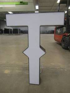 lot 135 image: Lighted Letter T Outdoor Signage, Transformer Not Included. Approximate Dimensions 20 x 5.25 x 28 Tall - USED FOR RETAIL BRAND MN HOME OUTLET.