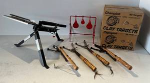 lot 95 image: Group Of Clay Pigeon Items Including  5 Pigeon Throwers  1 Spring Loaded 4 Hand Held And Two Cases Of Clay Pigeons ( NIB )