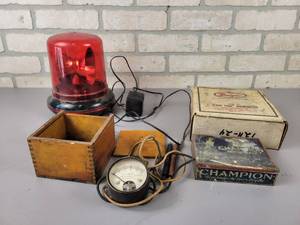 lot 725 image: Vintage Beede Electrical DC Voltmeter with wood Case, Tin Champion Spark Plug Case, 110V Strobe Light (works) and More