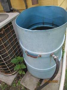 lot 233 image: Rain barrel with long hose attached
