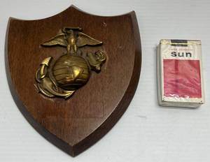 lot 189 image: Vintage U.S.M.C. Wood Plague With Brass Emblem & Unopened Pack Of Korean Cigarettes Given Out At President Carters Visit. (Staff Members & Attendees Only)