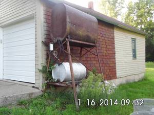 lot 10 image: Vintage 100-gallon metal tank on tall metal framed stand