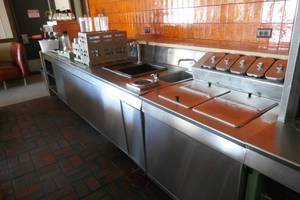 lot 18 image: Stainless counter with ice cream dipper, sink, water spigot, cup storage