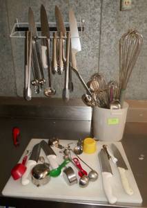 lot 115 image: Knives, tongs, whisks, spoons, measuring cups and cutting board