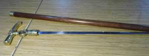 lot 11 image: Collectible Walking Cane with firefighter symbol and crest design as well as a sword hidden under the handle.