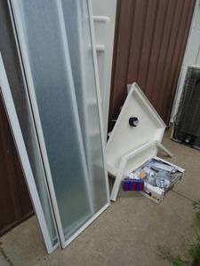 lot 124 image: Corner shower unit with base, drain, sides, door & assorted plumbing parts. As shown.