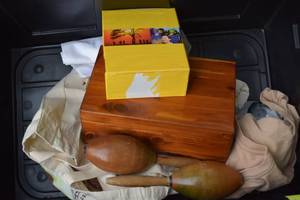 lot 15 image: Bin with Wood Box, Pillows, Rosseta Stone, Morracas