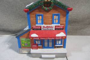 lot 62 image: Coca Cola True Value Light Up Christmas Village Ceramic Hardware Store