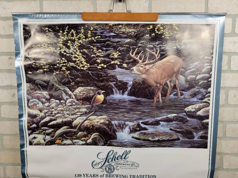 lot 412 image: 1986 Schells Beer Wall Calendar - New Ulm, MN - Approx. 31 x 42 - Features River Crossing by Artist J. Van Straalen - Lists the Blizzard Ale that Dairy Queen Sued Schells Brewery Over