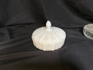 lot 56 image: Anchor Hocking Milk Glass Covered Candy Dish in Old Cafe Pattern and Vintage 1970s Avon Covered Clear Glass Lidded Candy Dish