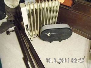 lot 16 image: Adjustable metal bed frame, oversized oil heater as well as a commercial toilet paper dispenser.