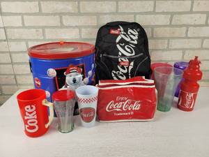 lot 179 image: Large Lot of Assorted Coca-Cola Collectables - Backpack, Lunch Cooler, Cups and Santa Bear Tin - NO SHIPPING