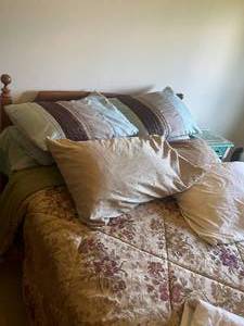 lot 132 image: Full Size Headboard with separate frame, mattress, box spring and bedding.