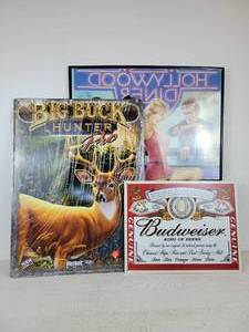 lot 711 image: BIG BUCK HUNTER PRO Metal Sign, Budweiser Tin Sign, and Hollywood Diner Poster in Frame