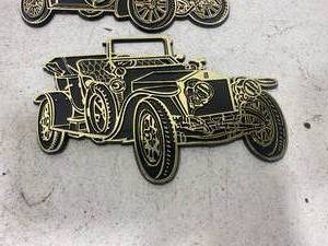 lot 139 image: Pair of Invicta Plastics 1968 Black with Gold Cars Wall Plaques