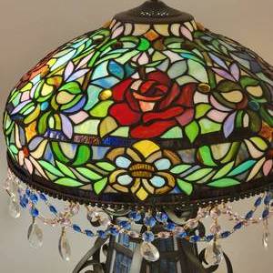 lot 90 image: Tiffany Style Stained Glass Table Lamp  Roses with Blue Prism Swag