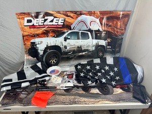 lot 24 image: Jeep and Chevy Banners, Blue Line and BLM Flags, Fishing Rod, Etc
