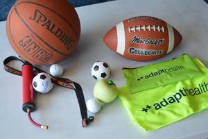 lot 32 image: Football, Basket ball, air pump, stress balls, Cooling cloth and pouch, key chain lanyard, Golf balls.