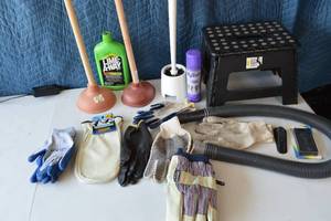 lot 38 image: Leather gloves, dipped gloves, winter work gloves, step stool, 2 plungers, toilet bristle brush and holder, dyzolv spray and spot remover, cloth gloves, cold winter mittens, door stopper, magnetic hide a key, lime away, vacuum hose attachment.