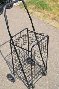 lot 48 image: Foldablecollapsible folding metal cart, powder coated black stainless steel, comfort grip padded handle, 2 sets of wheels-no need to tip to push it, spoked wheels, easy to move, closeable cover keepts items secure in the basket, 1.5x1.5x3.5