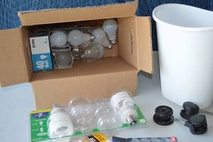 lot 88 image: Assorted Lot Light Bulbs, Trash Bin, Office Chair Wheels