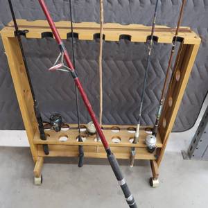 lot 19 image: WOODEN ROD RACK WITH MULTIPLE FISHING RODS AND REELS