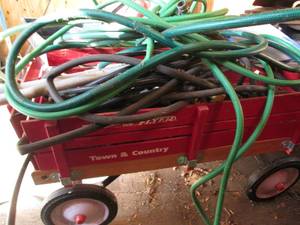 lot 248 image: Wooden crate style Radio Flyer wagon with assorted hoses and pool nets