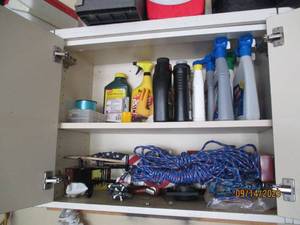 lot 87 image: Content of cupboard to include a large assortment of lawn chemicals,  fishing supplies,  ropes and more