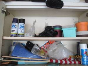 lot 88 image: Content of cabinet to include spray paints, planting supplies and more