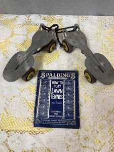 lot 16 image: Pair of Vintage Roller Skates and a Vintage Paperback Spaldings Athletic Library, How to Play Lawn Tennis
