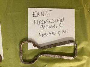 lot 31 image: Fleckenstein Brewing Co. Bottle Opener, and a  Duquesne Pilsner Bottle Opener, and a Vintage Bottle Capper with 20 Caps and Cork