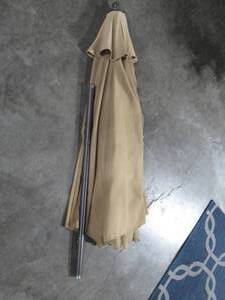 lot 209 image: 8 Tan Tilting Patio Umbrella - used condition