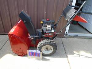lot 101 image: Yard Machine 8 hp snow blower with electric start. Used condition. Tested & works. As shown.