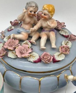 lot 182 image: Vintage Cupid Rose Topped Music Box, Lego Japan Dutch Lady & Porcelain Mug