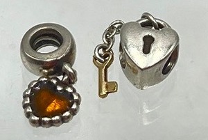 lot 18A image: Two Heart Themed Sterling Pandora Charms including a Pandora Sterling Heart Locket Charm