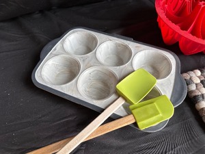 lot 198 image: Assorted Baking Supplied Silicon Bundtt and Muffin Pan, Wool Trivet and Oven Mits