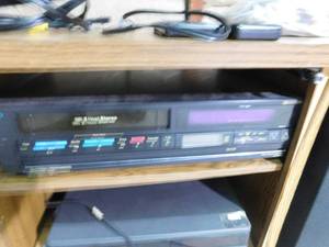 lot 2 image: TV stand with HQ VHS 2 head stereo and Hytachi VHS player and 2 Case speakers