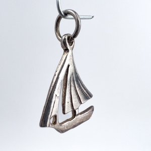 lot 69 image: Sailboat, Unknown Maker, Sterling Silver One-Part Stamped Charm.