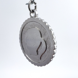 lot 84 image: Girl Head Profile, Unknown Maker, Sterling Silver One-Part Stamped Charm.