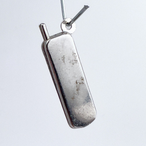 lot 119 image: Cordless phone, Unknown Maker, Sterling Silver One-Part Stamped Charm.