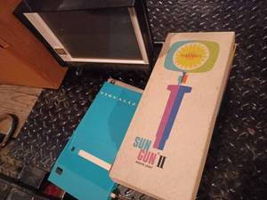 Box with a Vintage Polaroid Land Film Holder, a Sun Gun II Movie Light, and Vintage Camera Accessories