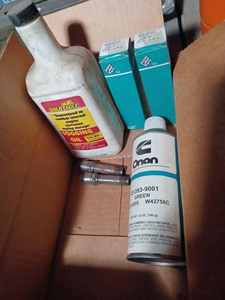 OMC Service Technician Guide, Can of Onan Green Spray Paint, Two Onan Spark Plugs, and a Bottle of Gold Eagle Fogging Oil