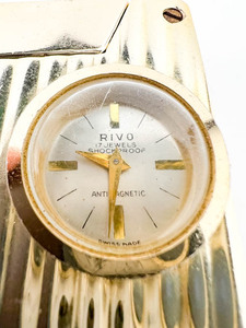 lot 56 image: Rivo Watch Lighter yellow base metal Mechanical Watch. Parts missing.