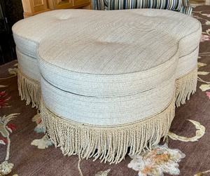 lot 175 image: Upholstered Clover Shaped Ottoman with Fringe Accents on Casters