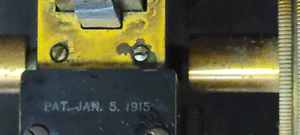 lot 25 image: Microscope - Brass and Iron with a 1915 Patent Date and Wooden Case