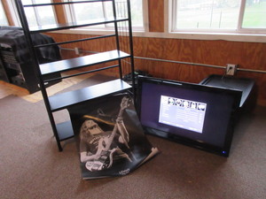 lot 243 image: BOOKSHELF, WALL MOUNT TV AND LEMMY (FROM MOTORHEAD) POSTER